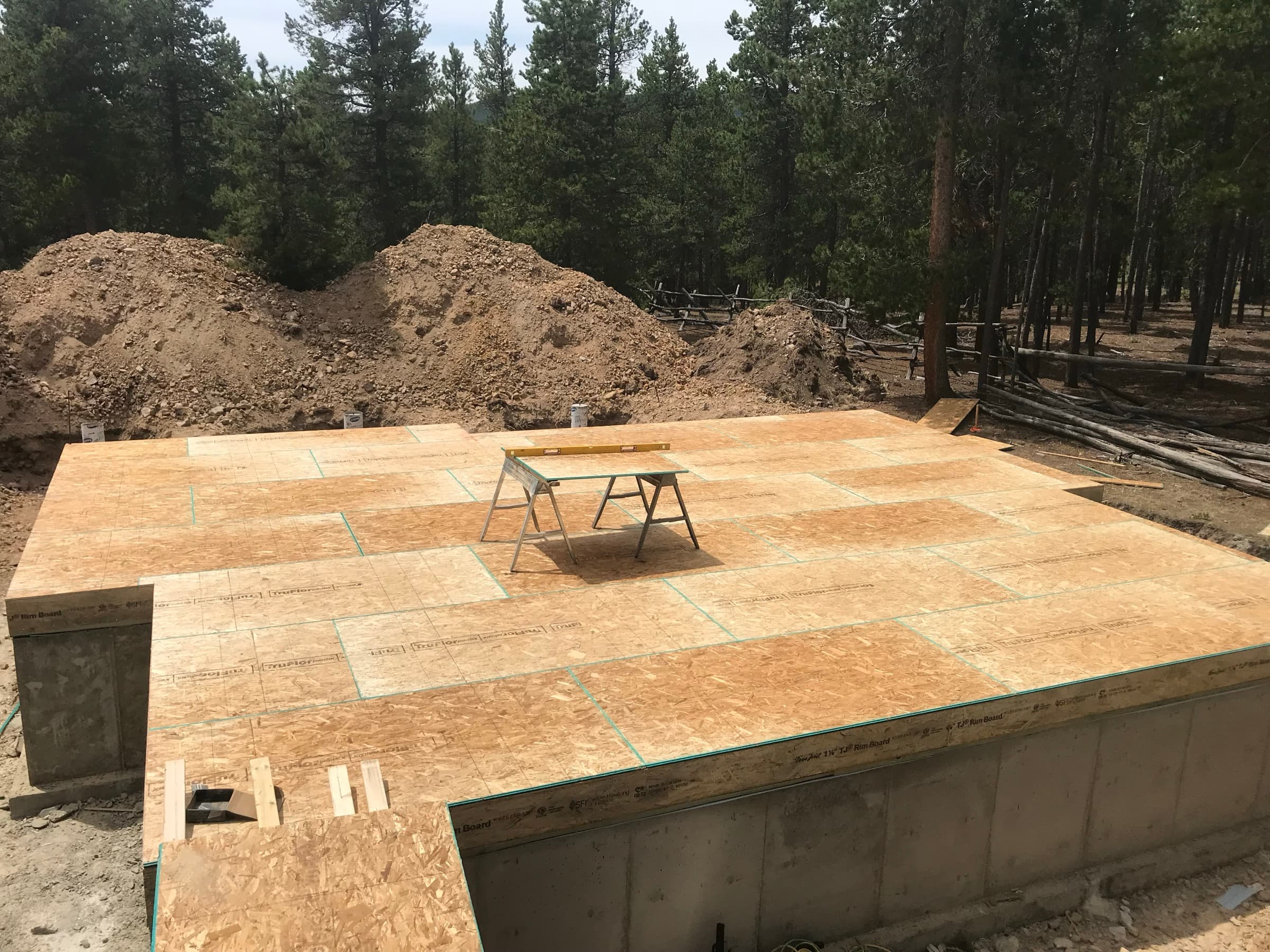 OSB subfloor over the new foundation in the trees