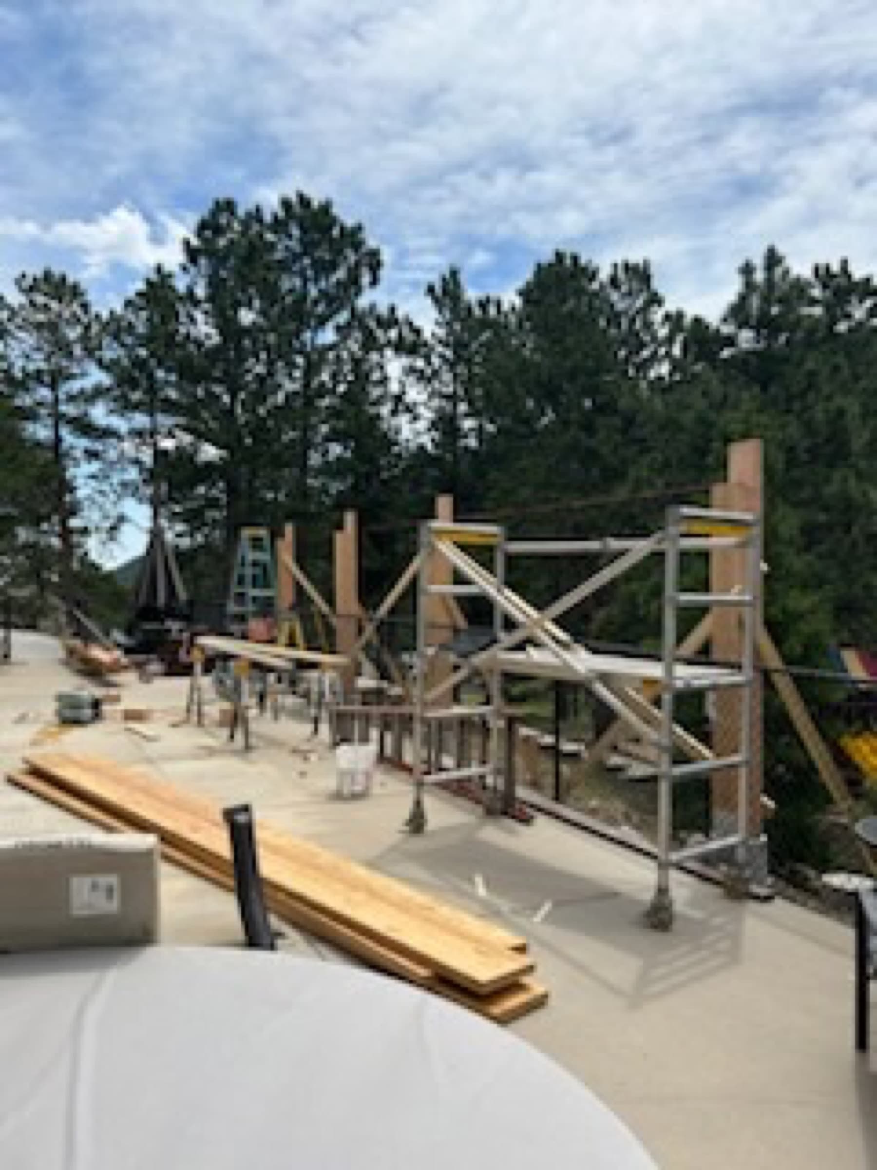 Deck posts set on a patio before the timber frame went up