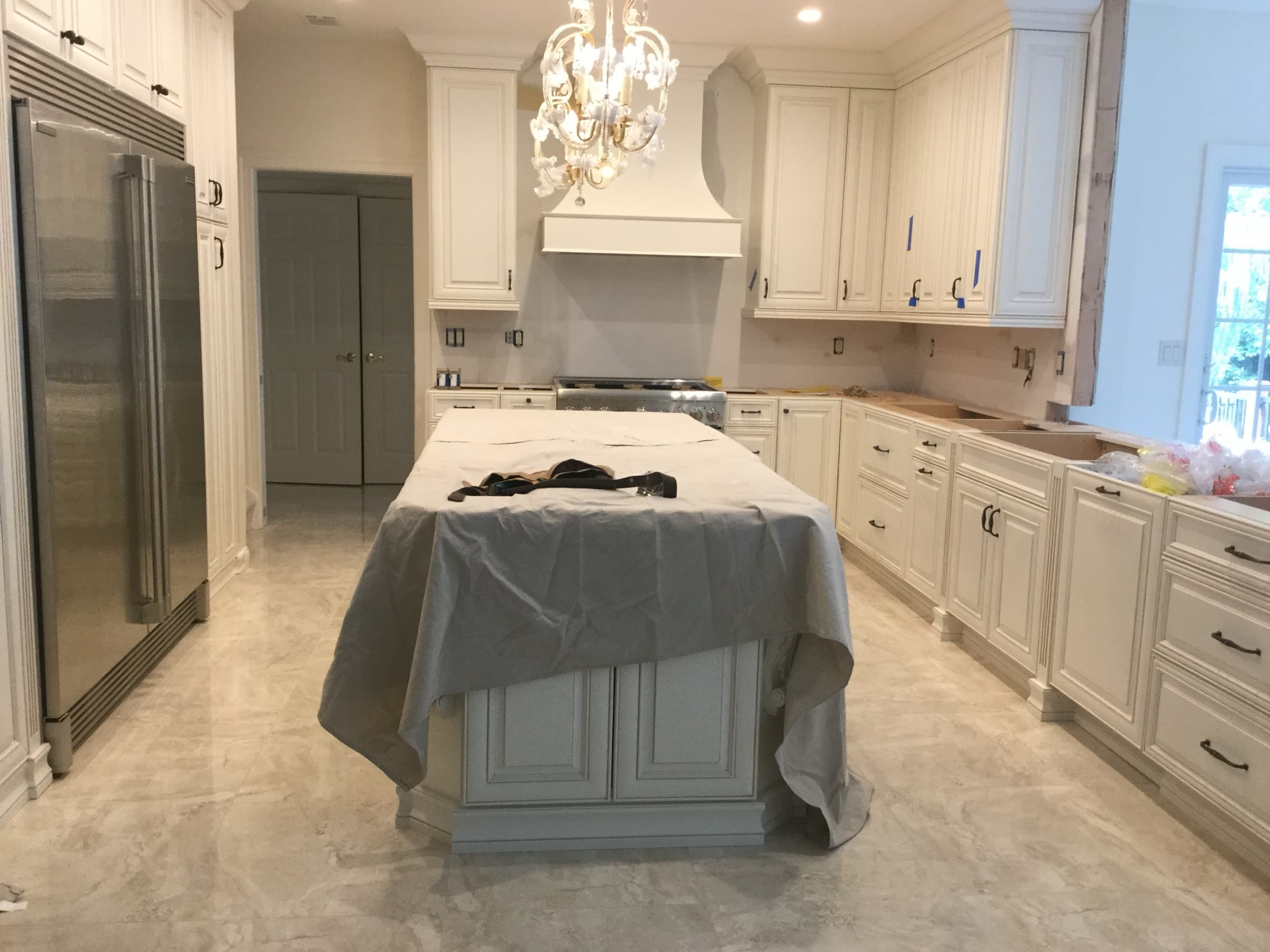 White kitchen during install with the island protected