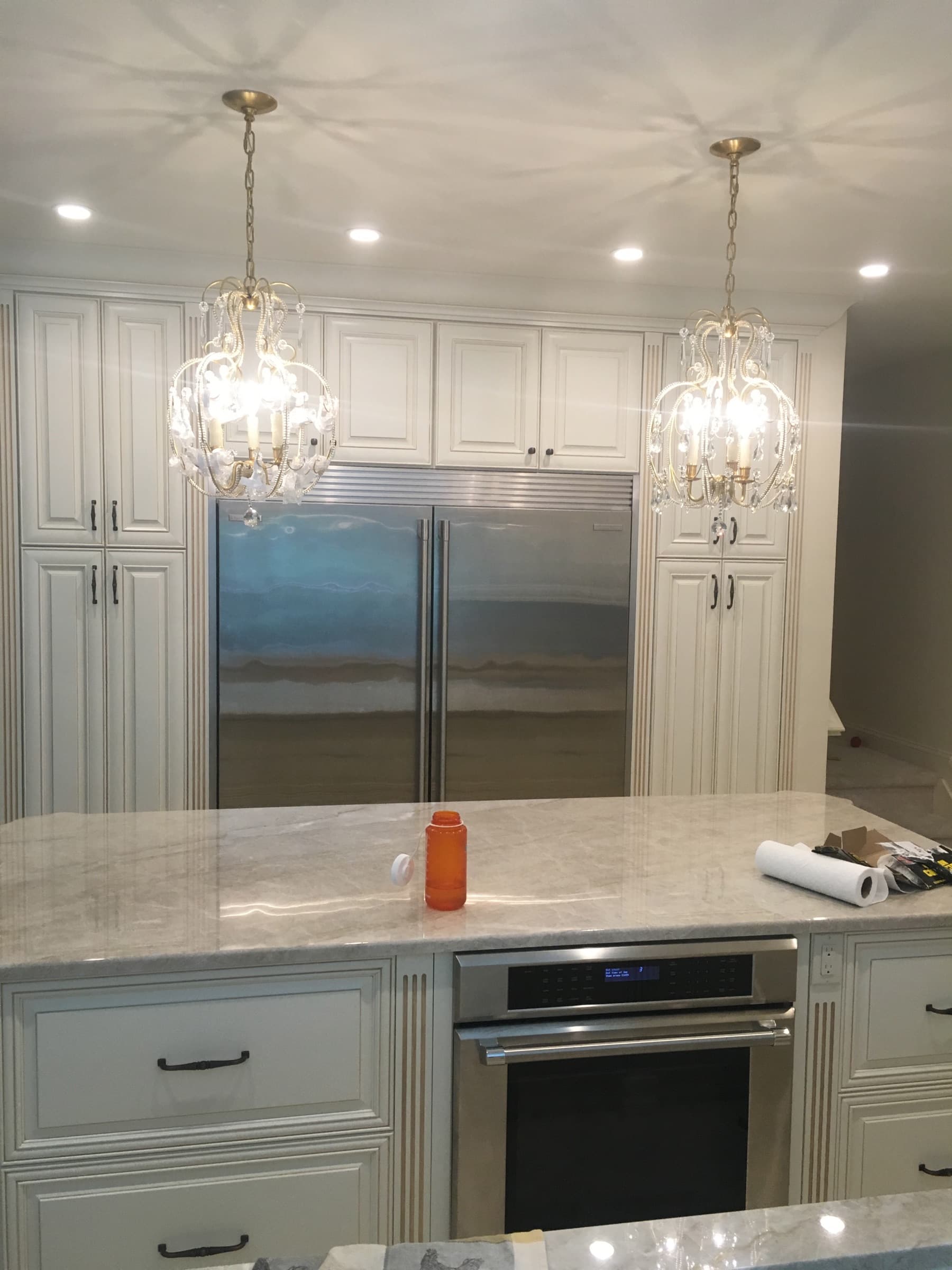 Kitchen island with marble-look stone and a wall oven below
