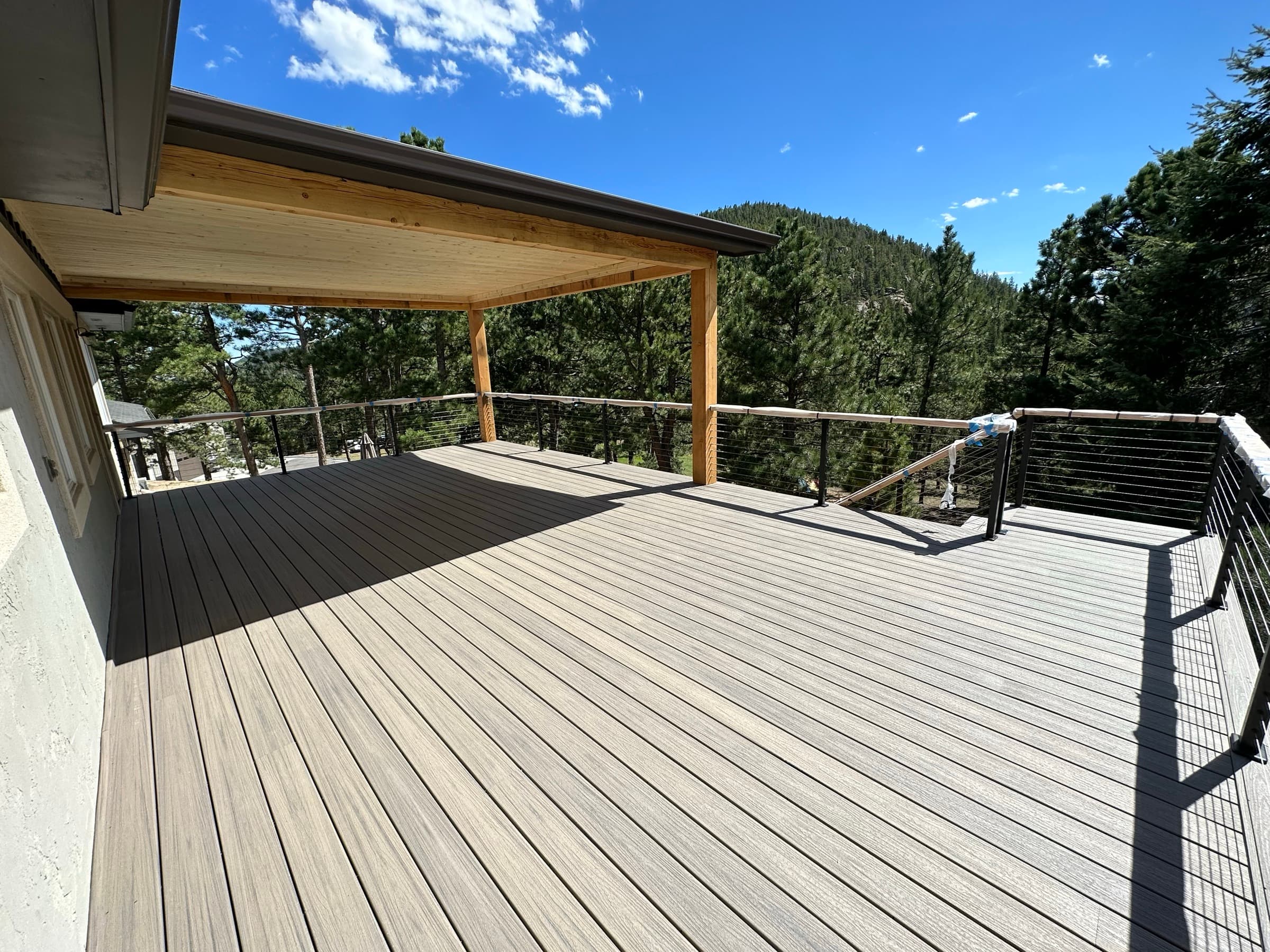 Finished covered deck with composite boards and cable rail