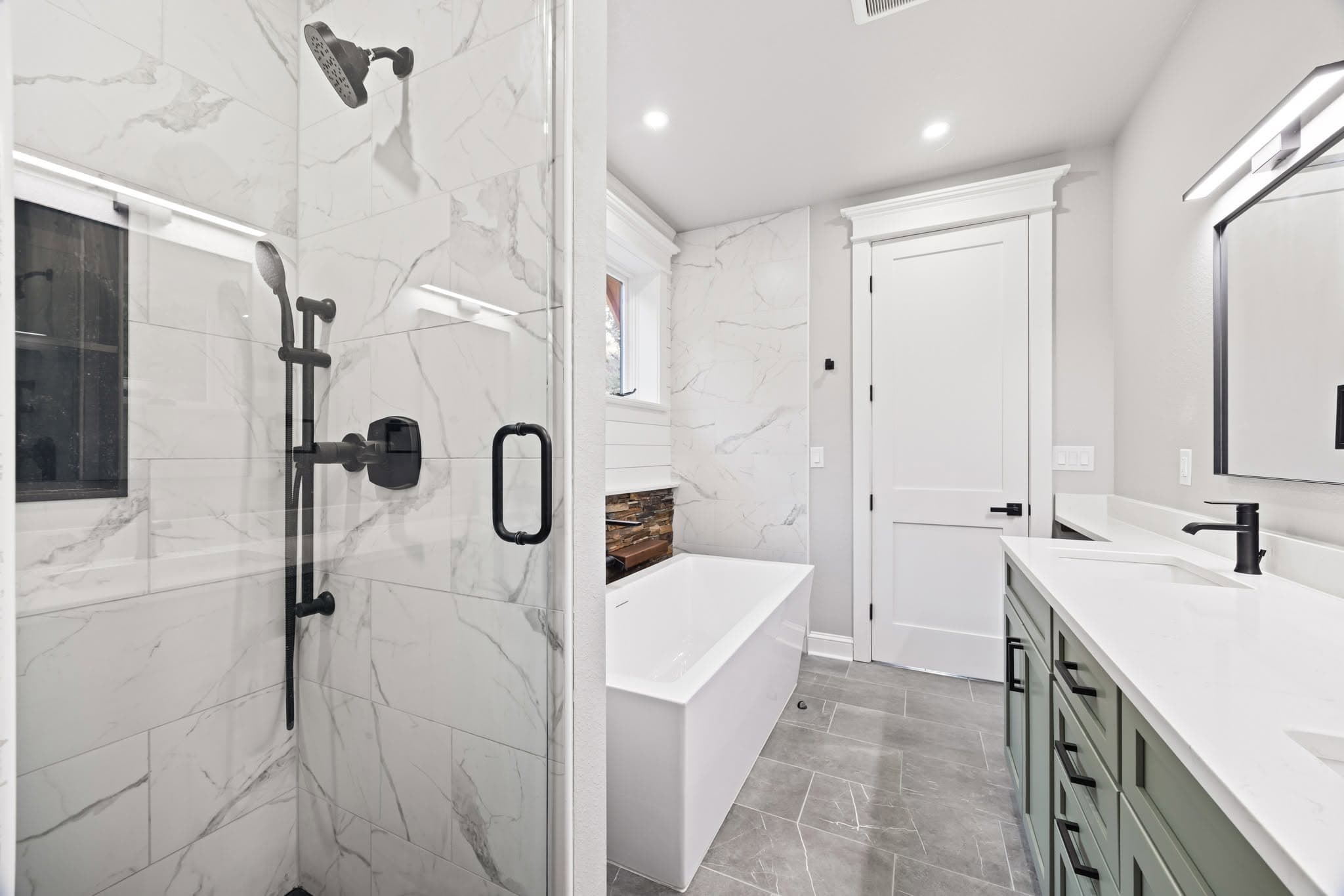 Primary bathroom with a glass walk-in shower, freestanding tub, and sage vanity