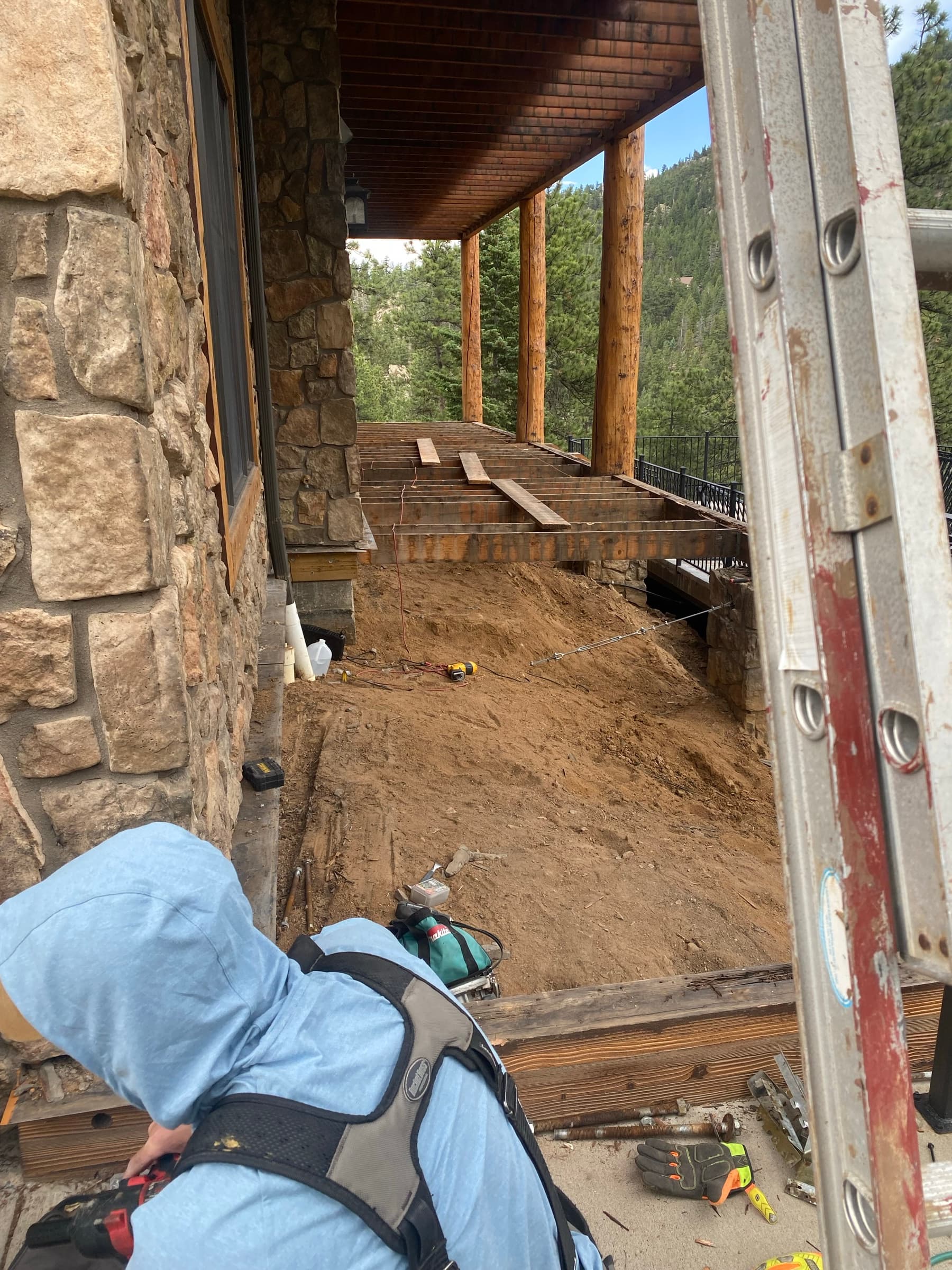 Deck structure opened up on a stone-and-log house