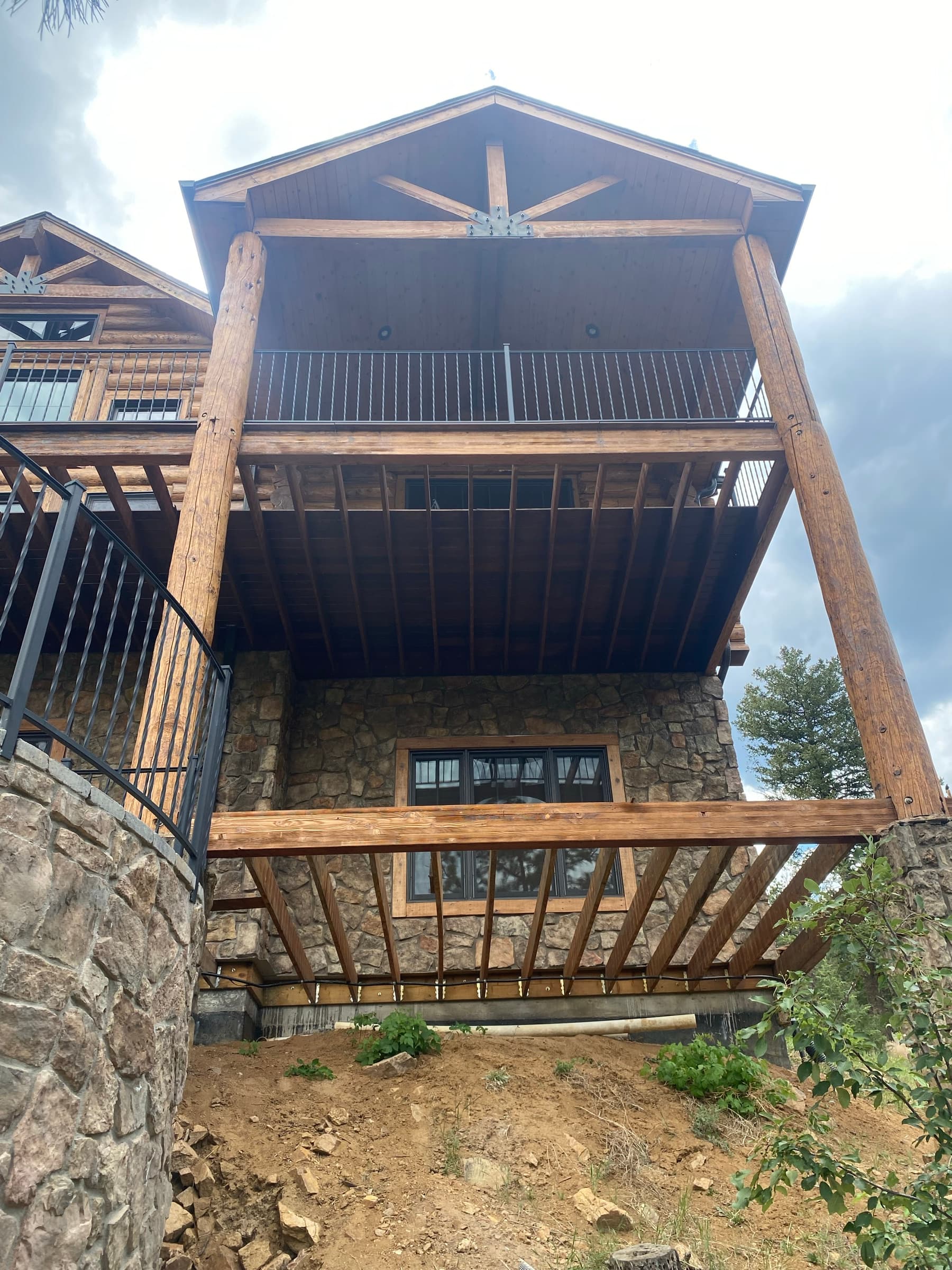 Deck framing on a hillside log house