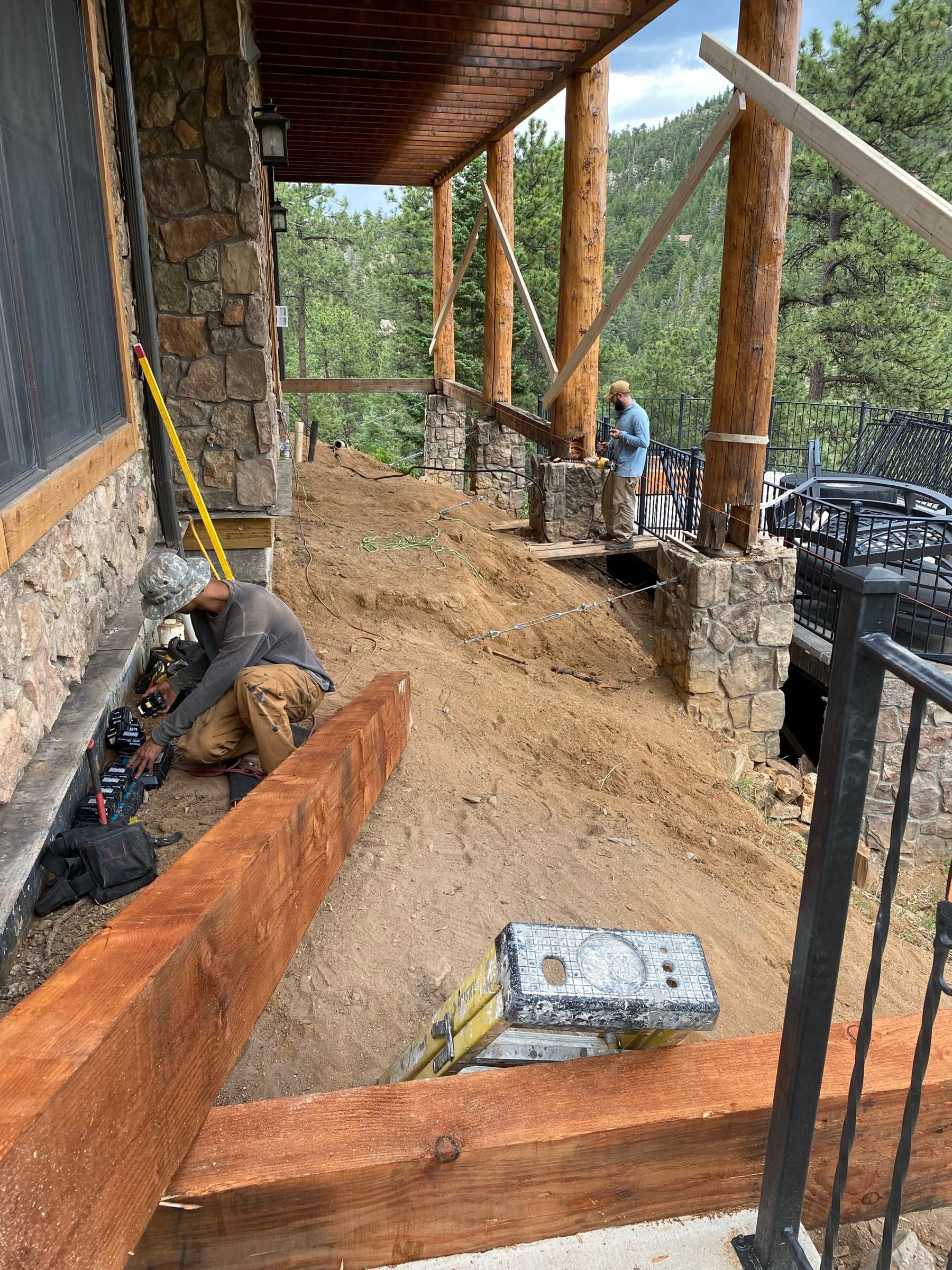 Crew setting log columns on stone pedestals
